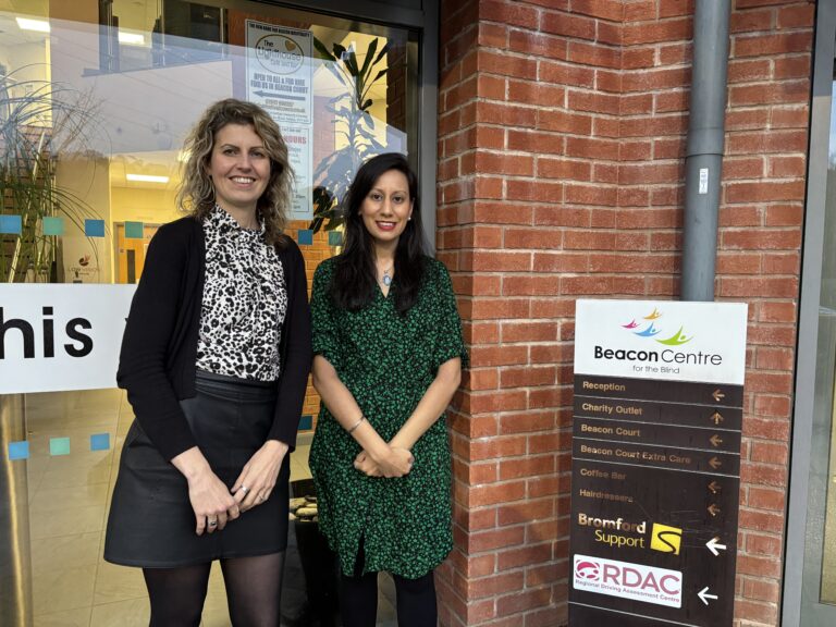 On the left is the Beacon Centre Chief Executive Lisa Cowley with the Dudley MP Sonia Kumar. Both are stood with their hands in front of them smiling towards the camera.